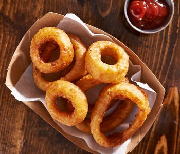 basket of onion rings shot from top overhead view with ketchup on wooden table